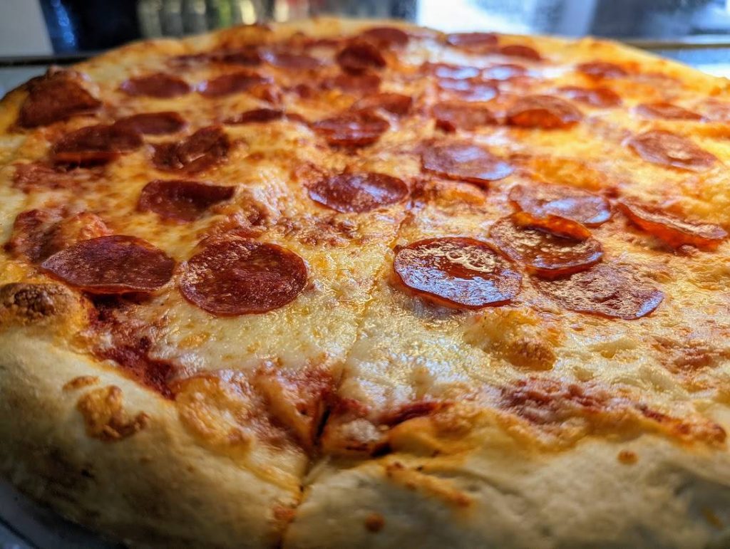 A pepperoni pizza on a metal pan.